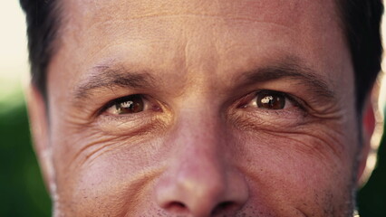 Macro close up of a man in 40s looking at camera smiling with wrinkles