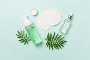 Face care products with eco pads on color background, top view