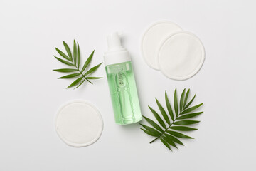 Foaming facial cleanser and with eco pads on color background, top view © Liami