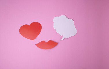 Fototapeta na wymiar On a pink background paper red lips and a heart and a white cloud for words