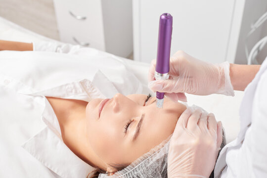 Beautician makes mesotherapy injection for rejuvenation woman face, anti aging non surgical cosmetic procedure in beauty salon. Cosmetologist hands in gloves makes facial micro needle injections