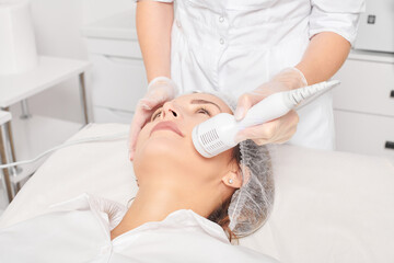 Beautician makes cryotherapy for rejuvenation woman face, anti aging cosmetic procedure with in...
