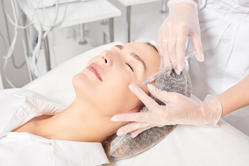 Cosmetologist makes rejuvenation injection in woman face skin, anti aging revitalization cosmetic...