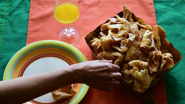 Footage with a table laden with lies or chiacchiere, a typical sweet of the carnival in Italy. Concept of traditional and local food, party , enjoy party time.