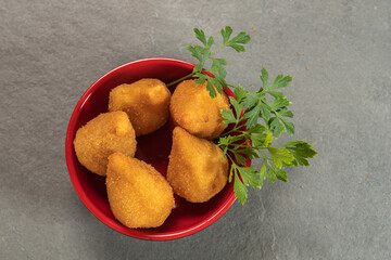 traditional fried coxinha in plate on slate background, popular brazilian snack