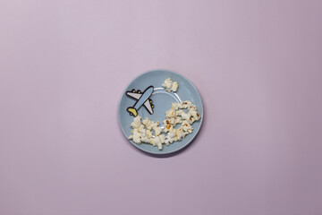 A toy plane on a purple background flying in circles with popcorn clouds.
