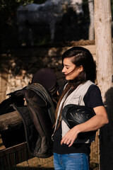 Brown hair woman preparing utensils for horse riding.