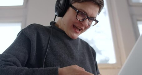 Middle age active woman emotionally plays videogames on joystick and laptop, midlife people hobbies