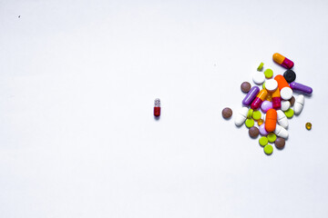 Bottle and scattered tablets on light-coloured background, top view. Space for text