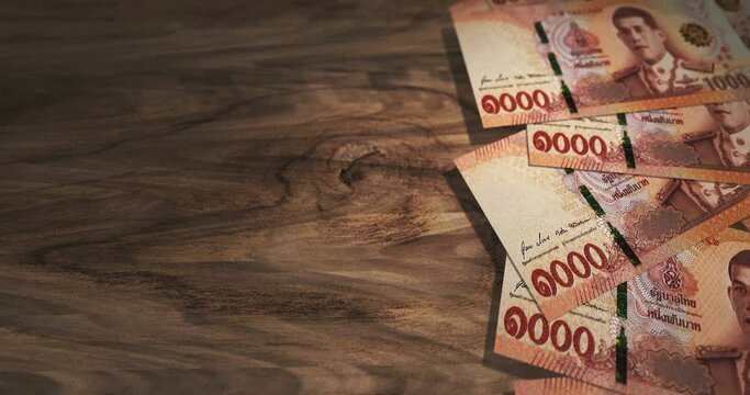 Thai Baht 1000 THB banknotes on the wooden table. Thailand currency paper notes 3D concept background. Seamless and looped.