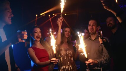Happy friends celebrate holiday sparkles lights cheers champagne Christmas night club disco party