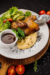 Baked quail with mashed potatoe and herbs on wooden background