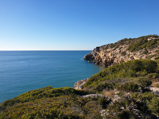 Fototapeta na wymiar Rocky beach, coastline with turquoise sea, hiking in Sitges, Spain