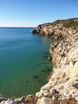 Rocky beach, coastline with turquoise sea, hiking in Sitges, Spain