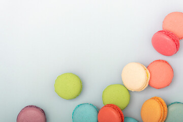 Macaroons, baked sweets from the pastry shop on white background.  Macaroons, baked sweets from the pastry shop on light blue background. Patisserie, confectionery, top view