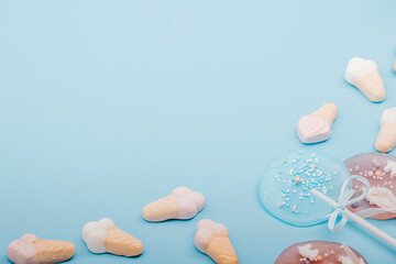 Sweets, flat lay, sweet food - macaroons, lollipops, candys, desserts on a blue background. Confectionery