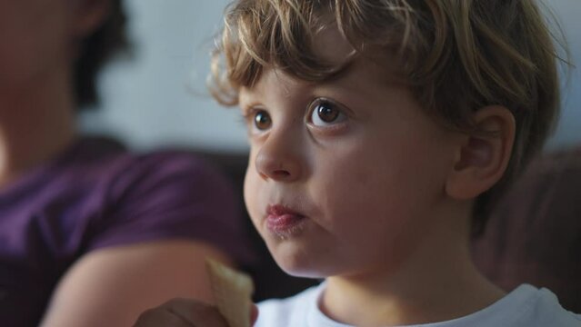 Kid snacking cookie biscuit. Close up face of male caucasian child eats dessert snack