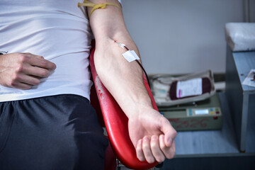 Detail with hand of a blood donor donating blood in a hospital