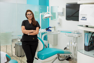 Portrait of a female dentist in her office, while standing with her arms crossed looking at the camera
