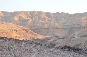 Panoramic view of the rocks, canyons and the desert and dry landscape surrounding Madaba, Jordan, on a bright sunny day.