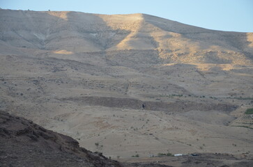 Panoramic view of the rocks, canyons and the desert and dry landscape surrounding Madaba, Jordan, on a bright sunny day.
