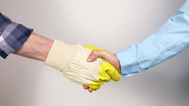 Handshake of a construction worker in a glove and a client.