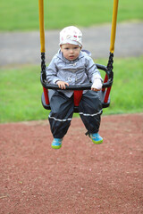 A little girl swings in the park