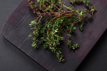 Sprigs of fresh green thyme on a wooden cutting board