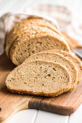 Sliced whole grain bread. Tasty wholegrain pastry with seeds on cutting board.