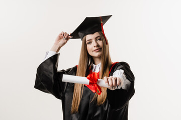 Masters degree diploma with red ribbon in hands of graduate girl in black graduation gown on white background. Graduate girl is graduating high school and celebrating academic achievement.