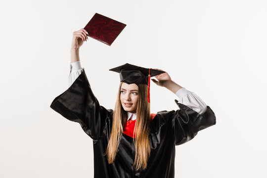 Confident student with diploma in graduation robe and cap ready to finish college. Future leader of science. Academician young woman in black gown smiling.