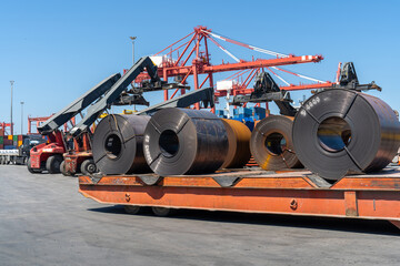 Tow and transporter trucks working  ort he transport of steel sheet rolls in the port area