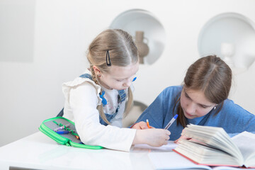 Cute sisters studying together at home. Education and relationship concept