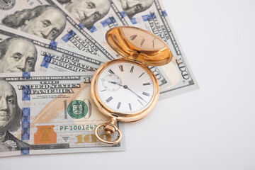 Macro shot of pocket watch face with 100 dollar bill Ben Franklin
money and time concept - old pocket watch on pile of american bill dollars