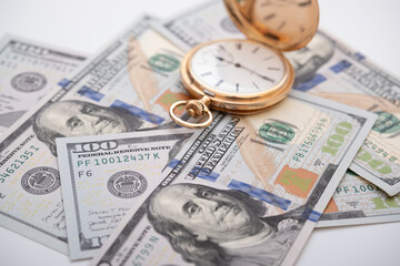 Macro shot of pocket watch face with 100 dollar bill Ben Franklin
money and time concept - old pocket watch on pile of american bill dollars