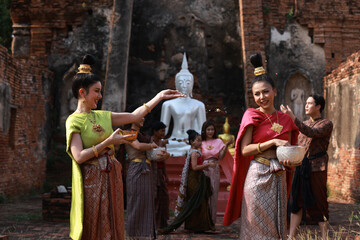 Obraz premium Asia people gathering at temple are splashing water together, Songkran festival culture and lifestyle
