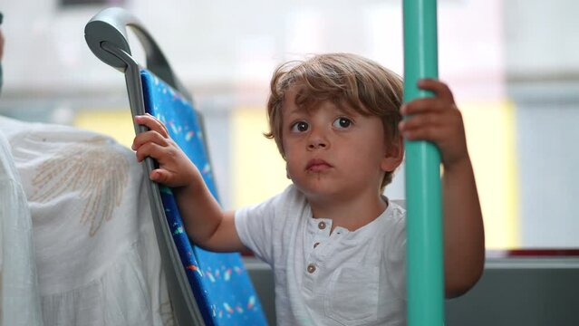 One small boy traveling by bus tram holding into bar pole. Child passenger lifestyle