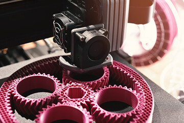 3D-printing of a planetary gear part from pink plastic filament in bright light. selective focus. Visible infill structure and layers. View on print area with print head. Modern production concept - obrazy, fototapety, plakaty