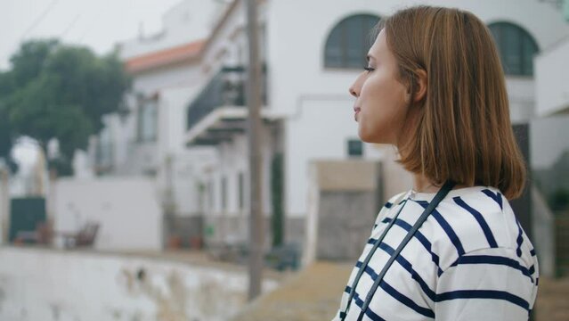 Travel girl enjoying city view closeup. Beautiful smiling tourist looking camera