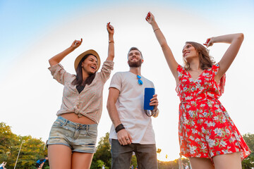 Obraz premium company of friends having fun together in park listening to music