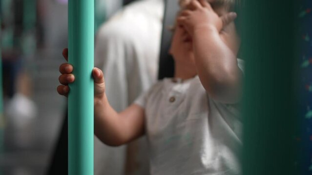 One tired small boy holding on bus rail. Exhausted male child passenger on moving transportation