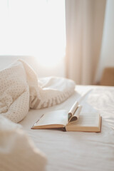 Cozy morning bed with a book with pages folded into a heart shape