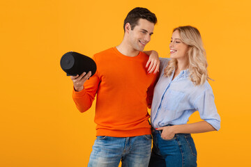 attractive stylish young couple holding wireless speaker