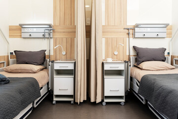 Large hospital ward with two beds for patients. Modern, clean ward, health restoration concept.