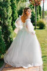 Fototapeta na wymiar rear view. the bride walks through the garden. 