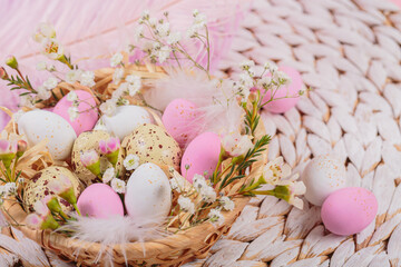 Fototapeta na wymiar Easter candy chocolate eggs and almond sweets lying in a bird's nest decorated with flowers and feathers on white background. Happy Easter concept.