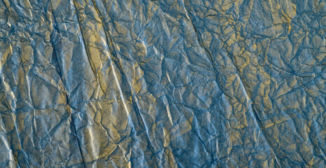 texture of crumpled colored blue and gold gift paper for banner background