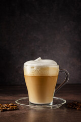 Cups of coffee drink, latte or mocha with milk foam. Glass mug, dark wooden background