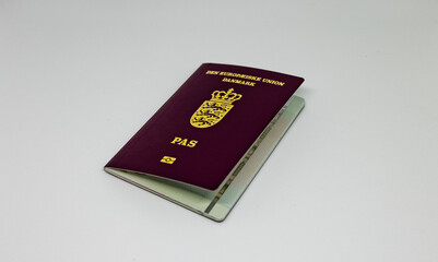 A photo of a Danish passport giving opportunity to travel round the world. The charasteristic sign of 3 crones with 3 lions on the red cover can be seen.