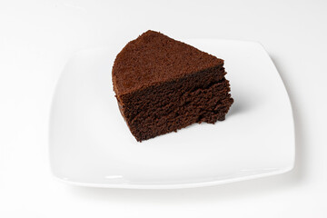 Porción de bizcocho de chocolate negro, casero, aislado sobre fondo blanco. Serie